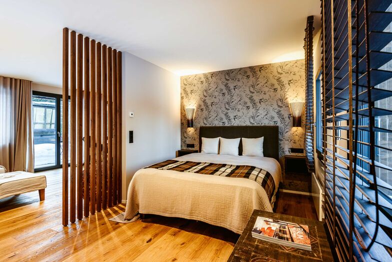 Die Holzstaketen sind ein Sichtschutz im offenen Schlafzimmer.