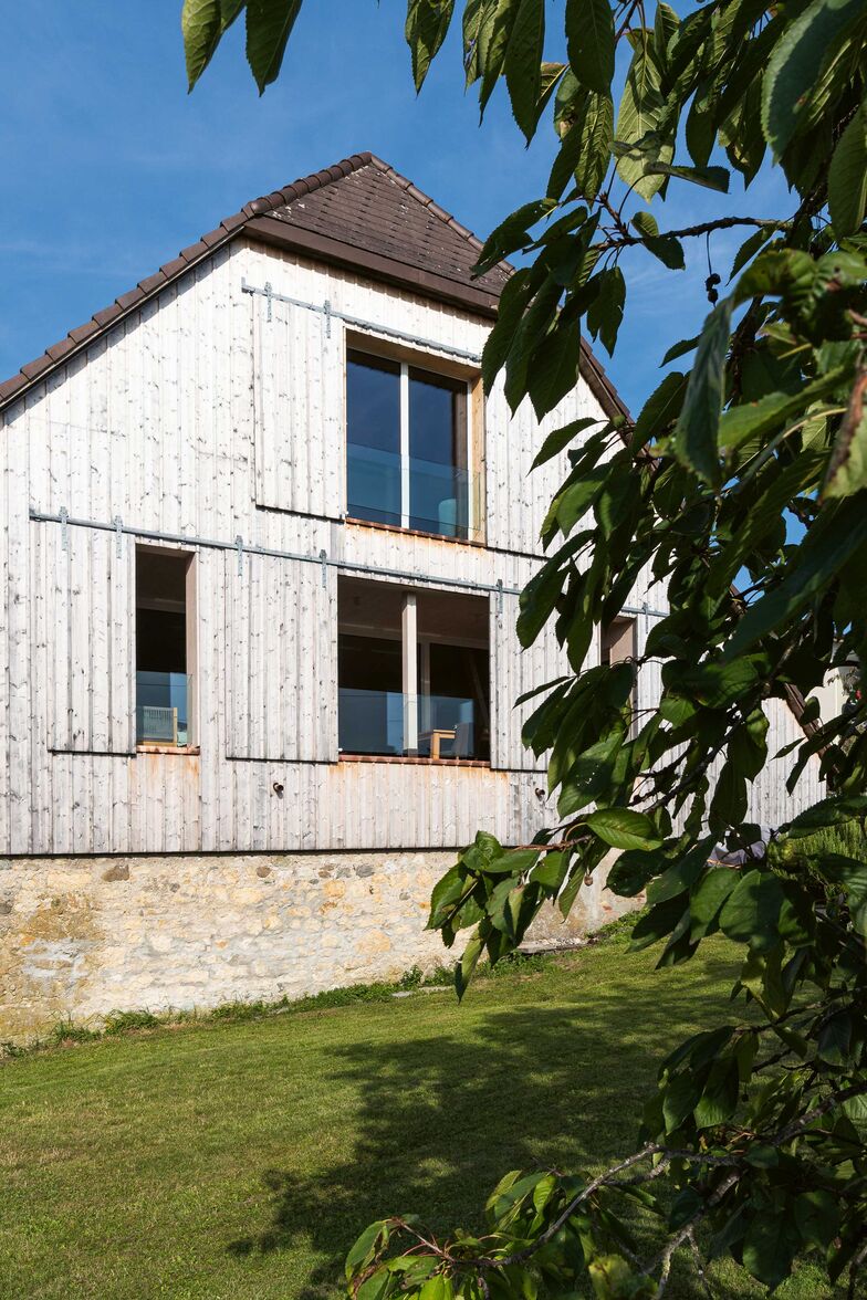 Während die grossen Fensterfronten viel Licht ins Haus lassen, schützen die Schiebefenster vor zu starker Sonneneinstrahlung.
